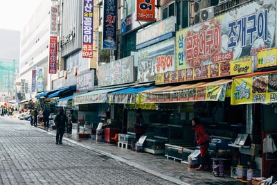 白天，人们在商店附近的人行道上行走